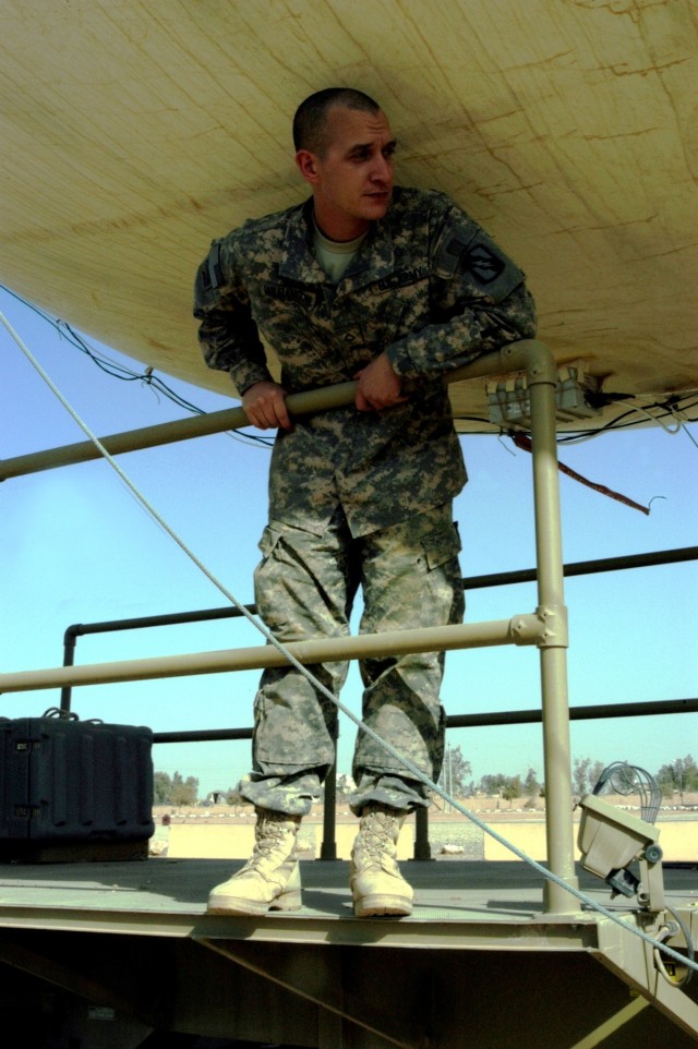 CONTINGENCY OPERATING LOCATION Q-WEST, Iraq - Pfc. William C. Williamson, an aerostat crewmember from Seattle, Wash., stands ready on the main platform of the mobile mooring station of Q-West's 17-meter Aerostat as his team prepared to hoist the...