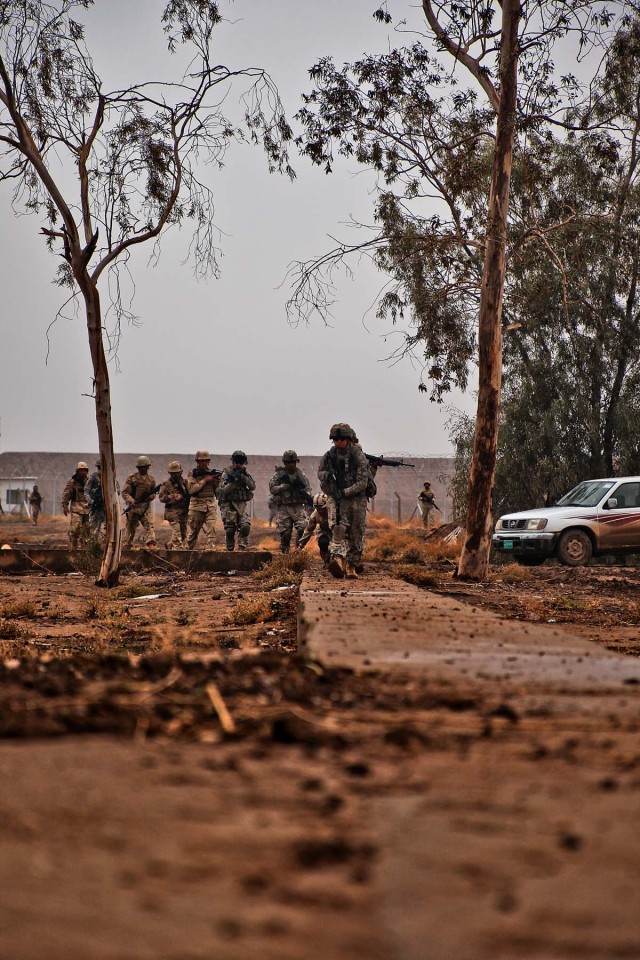 CAMP TAJI, Iraq-In a single-file formation, Soldiers from 1st Air Cavalry Brigade, 1st Cavalry Division, alongside Iraqi Army Soldiers from the 34th IA Brigade, move tactically through a training area to conduct cordon and search exercises at Camp...