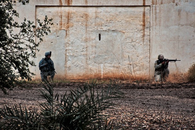 CAMP TAJI, Iraq-During a joint training exercise, Spc. Brandon McClary (left), from Lake Ozark, Mo., a rifleman in 1st Air Cavalry Brigade, 1st Cavalry Division, and a 34th Iraqi Army Brigade Soldier (right), pull security on the perimiter of the...