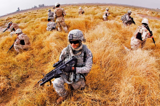 CAMP TAJI, Iraq-After conducting a cordon and search training exercise, Soldiers from 1st Air Cavalry Brigade, 1st Cavalry Division, along with 34th Iraqi Army Brigade Soldiers, position themselves to be picked up by a UH-60 Black Hawk Helicopter,...