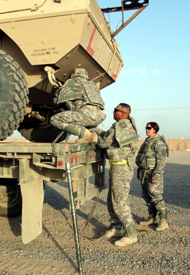 CONTINGENCY OPERATING LOCATION Q-WEST, Iraq - Sgt. Asia Thompson (left), of Lawrenceburg, N.C., and Spec. Steven Thompson, of Tarrytown, New York, inspect the tie-down of an Armored Security Vehicle under the watchful eye of Sgt. Denise Labo,...