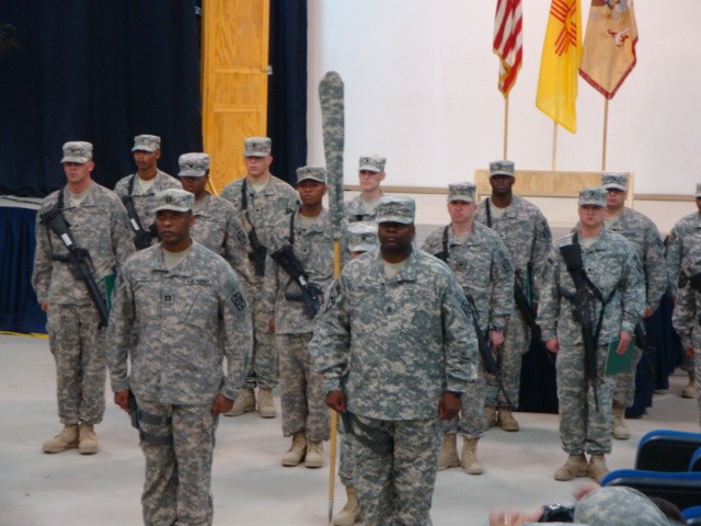 Capt. Dwight O. Smith and 1st Sgt. Joseph T. Walden, the commander and senior noncommissioned officer of the 506th Quartermaster company, stand with their unit during the ceremony Nov. 16 at the Contingency Operating Site Marez Diamondback Theater. (...