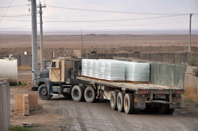 An 1174th Transportation Company, 395th Combat Sustainment Support Battalion, 15th Sustainment Brigade, armored truck hauls thousands of water bottles to be delivered to a group of Marines and others here Nov. 18. (U.S. Army photo by Sgt. Matthew C. ...