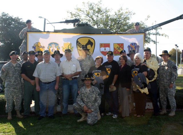 Unit members assigned to the 4th Brigade Combat Team, 1st Cavalry Division "Long Knives," along with former Vietnam Veterans and spouses pose for a group picture in front of the unit's headquarters as part of a Veteran's day tribute and effort to...