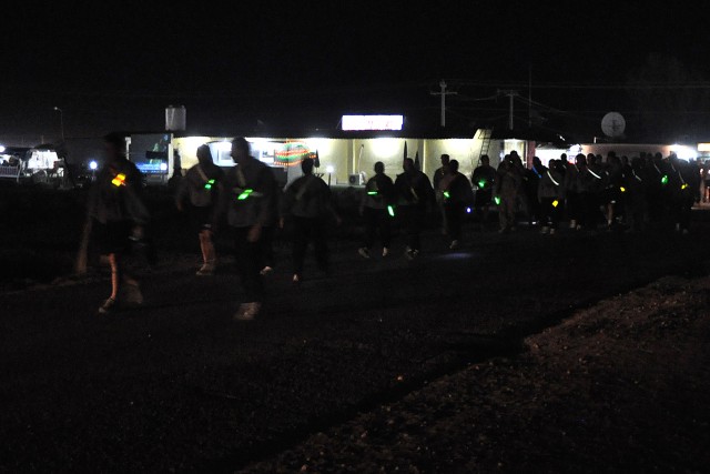 Service members at Contingency Operating Location Q-West, Iraq, walk down the street here Nov. 20 during the 395th Combat Sustainment Support Battalion's "Shine the Light Walk." The walk was intended to raise awareness of sexual assault...