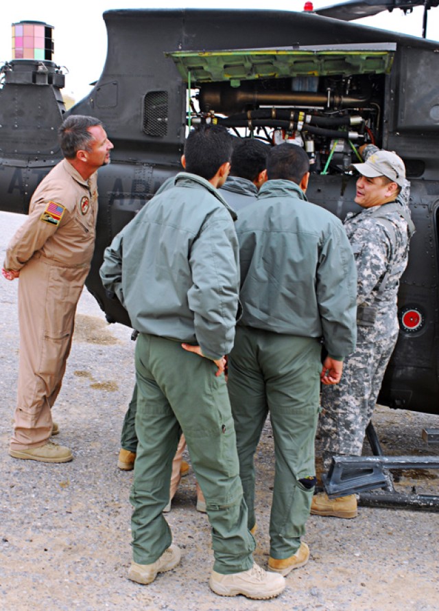 A group of Iraqi Air Force students training to become helicopter pilots watches closely as Chief Warrant Officer Steve Bridges, a Hilo, Hawaii, native and the standardization instructor pilot for 2nd Squadron, 6th Cavalry Regiment, Aviation...