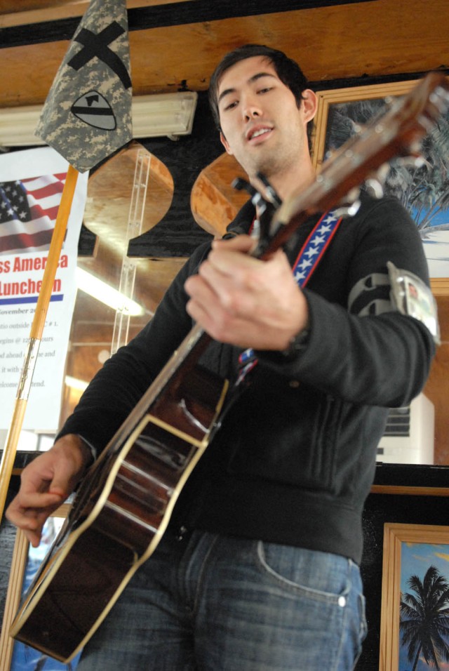 CAMP TAJI, Iraq - Springfield, Mo. native, Joe Keil, plays the guitar for worship music during the God Bless America Prayer Luncheon at the Command Sgt. Maj. Cooke Dining Facility on Camp Taji Nov. 25. "Amazing Grace", "God Bless America", and "I Saw...