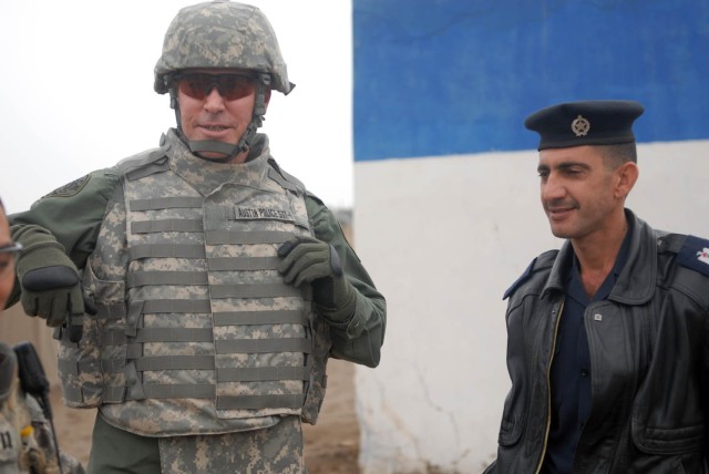 CAMP TAJI, Iraq - Fort Worth, Texas native, Chief David Carter (left), Chief of Staff for the Austin Police Department, speaks with Iraqi Army Maj. Thamir while visiting the Sheik Amir Iraqi Police Station, near Camp Taji, Nov. 20. The 1st Brigade...