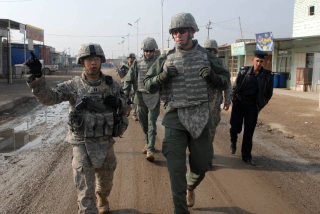 CAMP TAJI, Iraq - Capt. Alex Aquino (left), of Little Rock, Ark., the commander of Battery B, 1st Battalion, 82nd Field Artillery Regiment, 1st Brigade Combat Team, 1st Cavalry Division, discusses the relationship between the local Iraqi Police...
