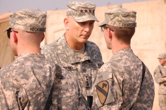 TAJI, Iraq - Gen. Ray Odierno, commander of Multi-National Force-Iraq, hands a challenge coin to Crestview, Fla. native, Pfc. William Robson, an artilleryman assigned to 1st Brigade Combat Team, 1st Cavalry Division, during Odierno's visit to Joint S...
