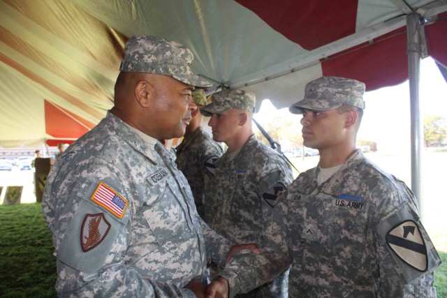 III Corps and Fort Hood Command Sergeant Major, Command Sgt. Maj. Arthur Coleman Jr. congratulates Pvt. Jarrick Rehn, Company A, 2nd Battalion, 7th Cavalry Regiment, 4th Brigade Combat Team, 1st Cavalry Division, for earning his Expert Infantry...