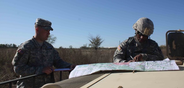 Staff Sgt. Sidney, Lintuan, assigned to Compay B, 2nd Battalion, 12th Cavalry Regiment.  4th Brigade Combat Team, 1st Cavalry Division plots a coordinate on a military map during Expert Infantry Badge testing Nov. 23. Lintuan was one of 14...