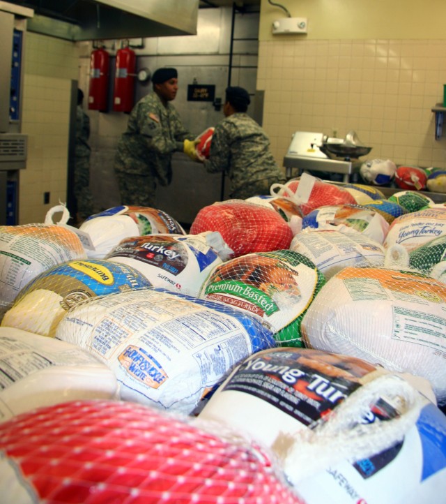 From left: Garrison Commander Col. Robert F. McLaughlin, Cindy McLaughlin and Garrison Command Sgt. Maj. James Kilpatrick prepare plates for the Salvation Army Thanksgiving dinner