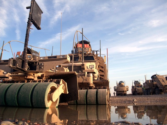 CONTINGENCY OPERATING LOCATION Q-WEST, Iraq - Reflected in an early winter puddle is the Self-Protection Adaptive Roller Kit (SPARKs) attached to a Mine-Resistant, Ambush-Protected truck's front, absorbing the damage of IEDs and shielding the...