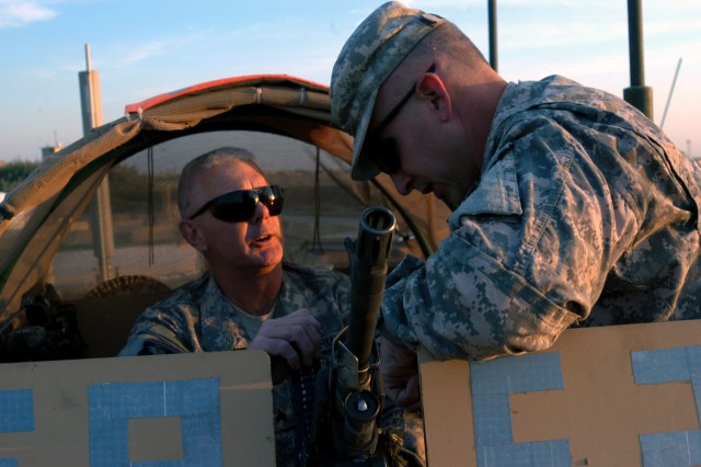 CONTINGENCY OPERATING LOCATION Q-WEST, Iraq - Sgt. Maxey Parish, a Rolling Fork, Miss., native and gunner with 1st Platoon, B Company, 198th Combined Arms out of Greenwood, Miss., chats with Lt. Col. Kerry Goodman, a native of Meridian, Miss., and...