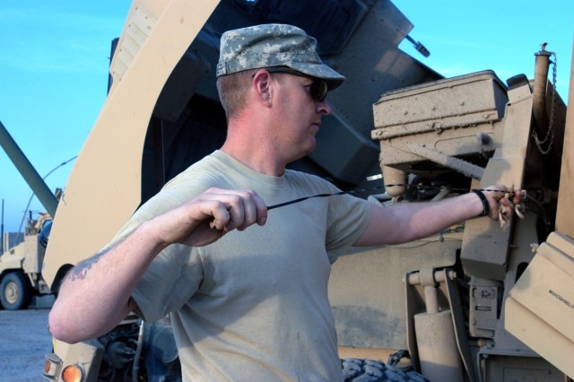 CONTINGENCY OPERATING LOCATION Q-WEST, Iraq - Spc. Michael A. Boucher, a Batesville, Miss., native, checks the oil in the Caimen variant of the Mine-Resistant, Ambush-Protected truck he drives with 1st Platoon, B Company, 2nd Battalion, 198th...