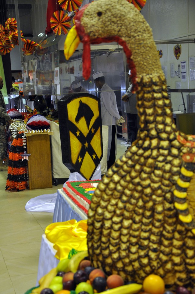 A large turkey made out of crackers, cereal, and dough sits on the serving line in the foreground while a "Wagonmaster" patch made of hardened sugar sits in the background. (U.S. Army photo by Sgt. Matthew C. Cooley, 15th Sustainment Brigade...
