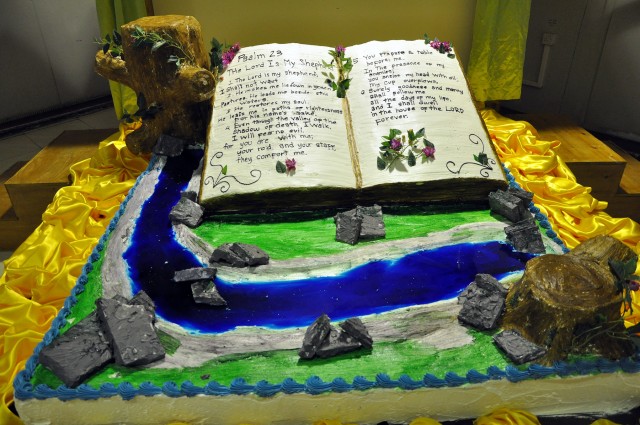 A 3-D cake made by Sixto Jimenez, a San Jose Del Monte, Philippines, native and head baker for the dining facility here, sits on display at Thanksgiving dinner next to a dining facility entrance here, Nov. 26, showing a Bible open to the 23rd...