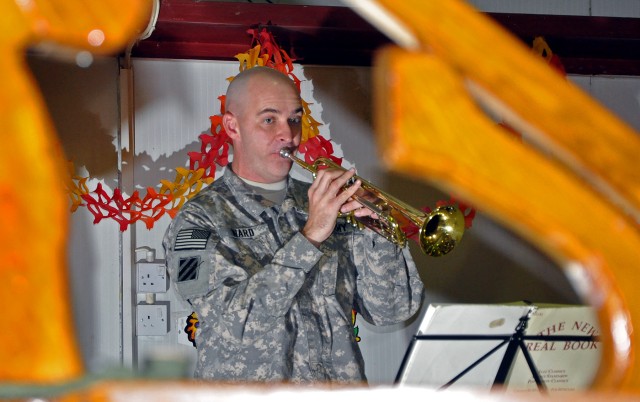 Chief Warrant Officer 2 Jonathan Ward, 3rd Infantry Division bandsmen, plays Christmas music on his trumpet with the 3rd Infantry Division's The Marne Jazz Ensemble behind a large model ship in the dining facility here Nov. 26 as part of the...