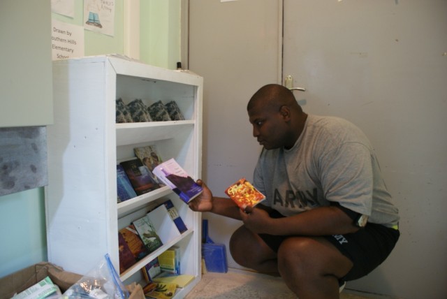 Spc. Shanesel Dawson, with the 1083rd Transportation Company from Shreveport, La., checks out reading material from the company feeding station. Dawson also serves as the company's spiritual advisor and worked as the chaplain's assistant on his...