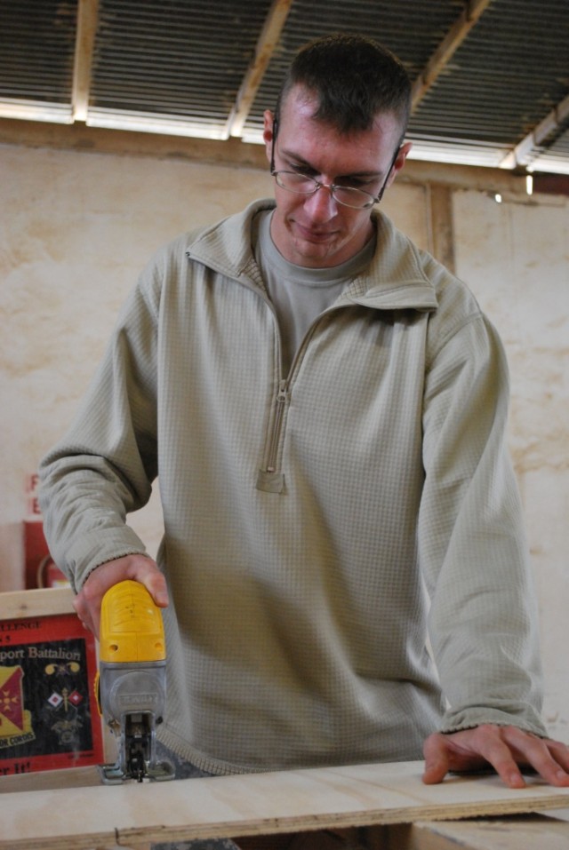 Sgt. Douglas Carroll, a mechanic with the Headquarters and Headquarters Company, 264th Combat Sustainment Support Battalion and Sanford, N.C., native works on his next project. Carroll built the battalion's spiritual feeding station bookshelves....