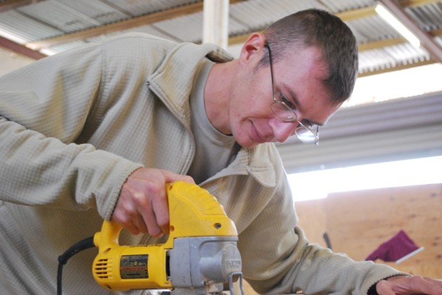 Sgt. Douglas Carroll, a mechanic with the Headquarters and Headquarters Company, 264th Combat Sustainment Support Battalion and Sanford, N.C., native works on his next project. Carroll built the battalion's spiritual feeding station bookshelves....