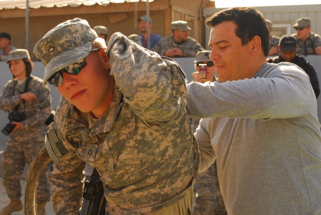 A Soldier with 1st Battalion, 8th Cavalry Regiment, 2nd Brigade Combat Team, 1st Cavalry Division, has his shirt signed by comedian Carlos Mencia at Joint Security Station McHenry in Kirkuk province, Iraq, Dec. 2. Mencia, and singers Kid Rock and Jes...