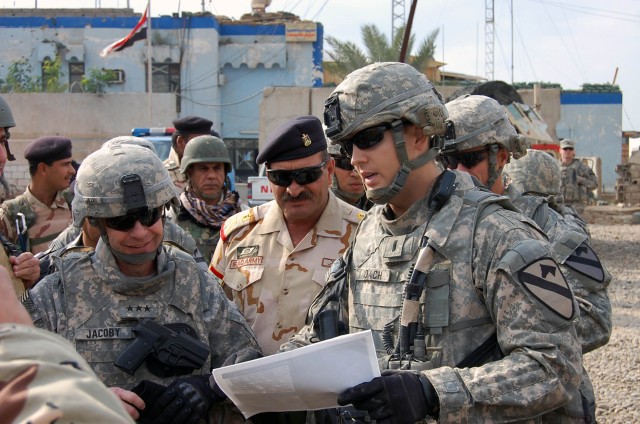 BAGHDAD- 1st Lt. William Roach (right), from Raleigh, N.C., gives a pre-mission patrol brief to Lt. Gen. Charles Jacoby (left), commander of Multi-National Corps Iraq, and staff Brig. Gen. Munam Abdul Sittar Dawuud (center), commander of the 37th...