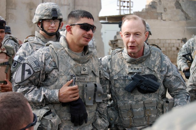 BAGHDAD-Lt. Gen. Charles Jacoby (right), commander of Multi-National Corps Iraq, asks Pfc. Luciano Rehak, from Chicago Heights, Ill., to pick a fellow member of his platoon to receive one of the corps commander's coins after returning from a...