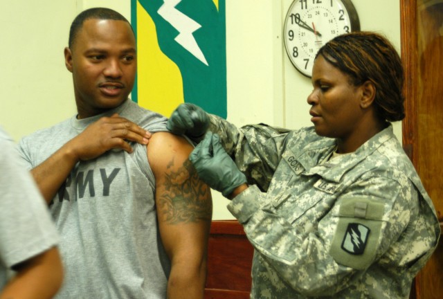 Staff Sgt. Tony T. Ware, the Department of Public Works noncommissioned officer in charge and a Grenada, Miss., native, receives a vaccination for the H1N1 flu virus from Sgt. Julia R. Goins, a senior medic and a Jackson, Miss., native, Nov. 28 at...