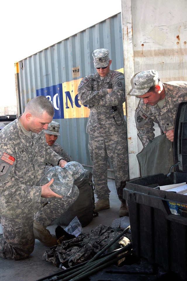 BAGHDAD - Sgt. David Shirley (left), a customs border clearance agent for the 150th Armored Reconnaissance Squadron, 30th Heavy Brigade Combat Team, inspects the contents of a footlocker, Dec. 11, for prohibited items, to ensure the Soldiers...