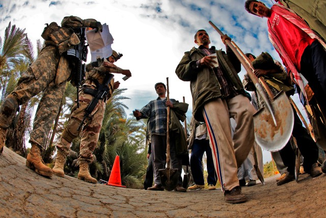 TAJI, Iraq - After taking control of a small intersection, Staff Sgt. Sasaki Palik (left), from Micronesia, a squad leader in 3rd Battalion, 227th Aviation Regiment, 1st Air Cavalry Brigade, 1st Cavalry Division, begins to check the ID cards of...