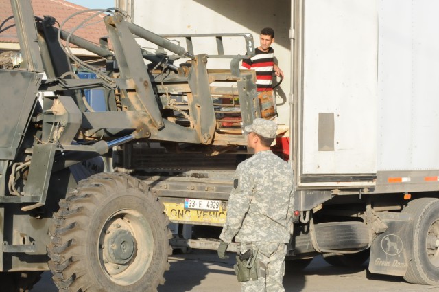 Capt. Estan N. Davis, commander of the Logistical Task Force 15 with Headquarter and Headquarters Company 15th Special Troops Battalion attached to the 15th Sustainment Brigade out of Fort Hood, Texas, watches his Soldier drive a fork lift to pick...