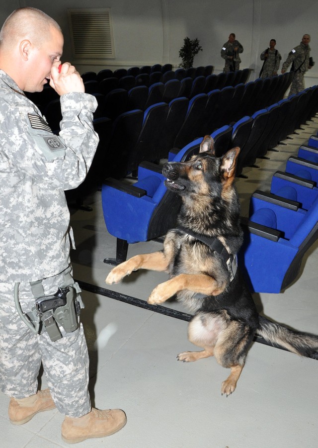 Staff Sgt. Cully Parr, a McBride, Mich., native and military police dog handler for the 178th Military Police Detachment, tells Sgt. 1st Class Rex, a patrol explosive detector dog for the 178th MP Det., to "speak" after a ceremony in which Rex was...