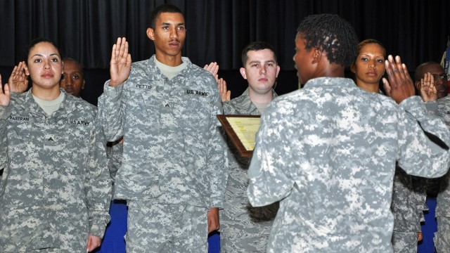 1st Sgt. Jeanette Short [foreground], Headquarters and Headquarters Company, 15th Special Troops Battalion, first sergeant, administers the Charge of the Noncommissioned Officer at an NCO induction ceremony in the Morale Welfare and Recreation...