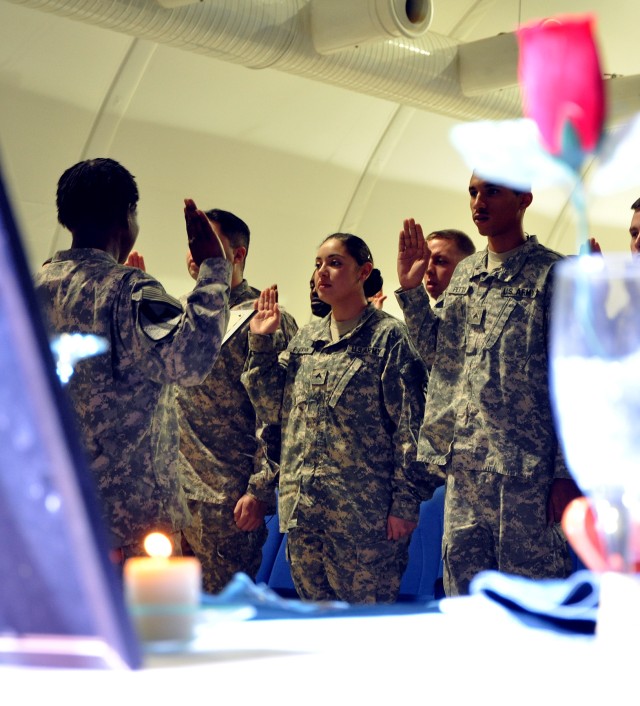 1st Sgt. Jeanette Short [left], Headquarters and Headquarters Company, 15th Special Troops Battalion, first sergeant, administers the Charge of the Noncommissioned Officer at an NCO induction ceremony in the Morale Welfare and Recreation tent here...