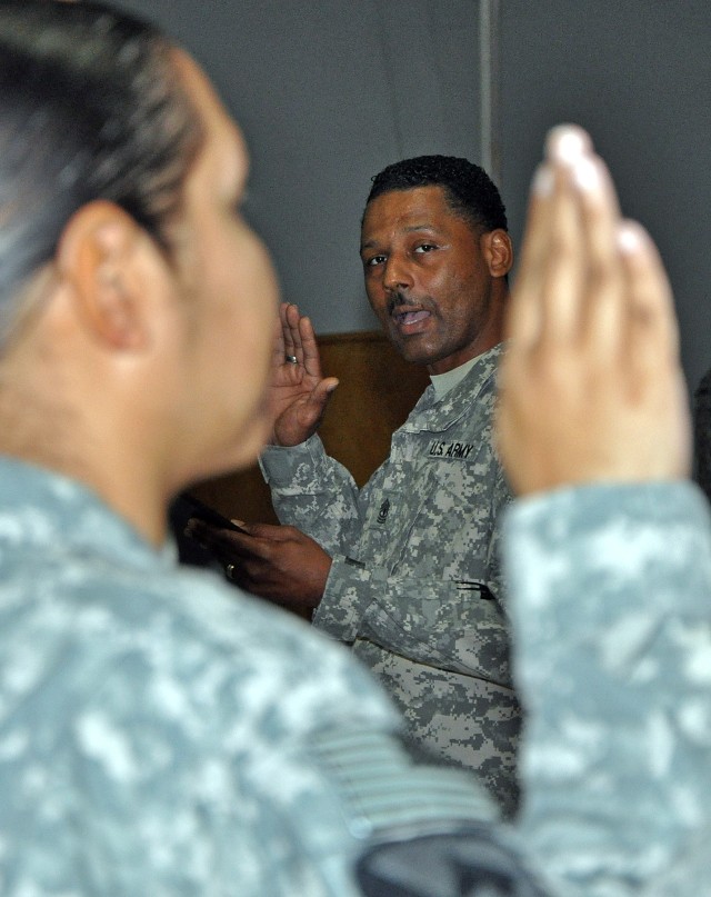 1st Sgt. Willie Johnson [background], A Company, 15th Special Troops Battalion, first sergeant, administers the Oath of the Noncommissioned Officer at an NCO induction ceremony in the Morale Welfare and Recreation tent here Dec. 12. (U.S. Army...
