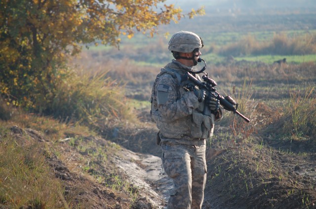 BAGHDAD- Sgt. Nathan Piper, a cavalry scout from Amboy, Ill., scans a field for signs of hidden weapons or explosives during a weapons search mission in Fahama.  U.S. Soldiers from conducted two days of raids and cache searches in rural areas east...