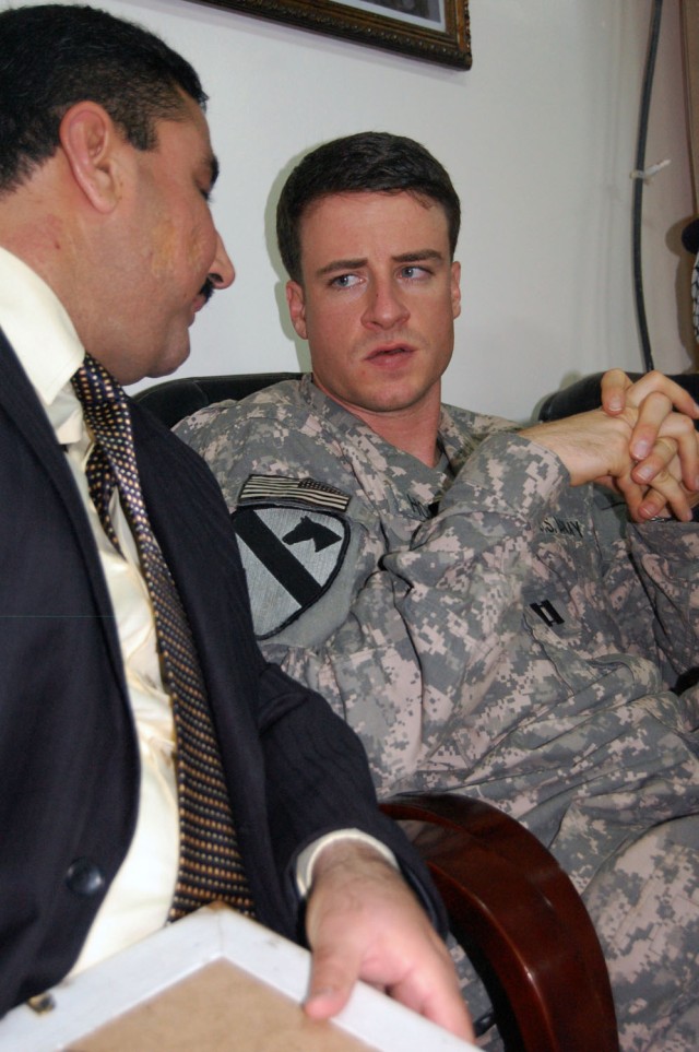 CAMP TAJI, Iraq- Little Rock, Ark. native, Capt. Matthew Hopper (right), commander of Headquarters and Headquarters Battery, 1st Battalion, 82nd Field Artillery Regiment, 1st Brigade Combat Team, 1st Cavalry Division, speaks to New Taji Nahia council...