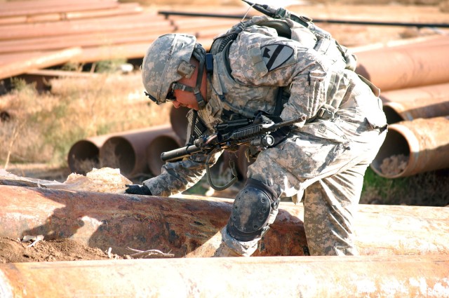 CAMP TAJI, Iraq - Redding, Calif. native, Staff Sgt. Jereme Espinosa, an armor crewman assigned to Company C, 2nd Battalion, 8th Cavalry Regiment, 1st Brigade Combat Team, 1st Cavalry Division, searches for weapons caches in a field of rusted pipes a...