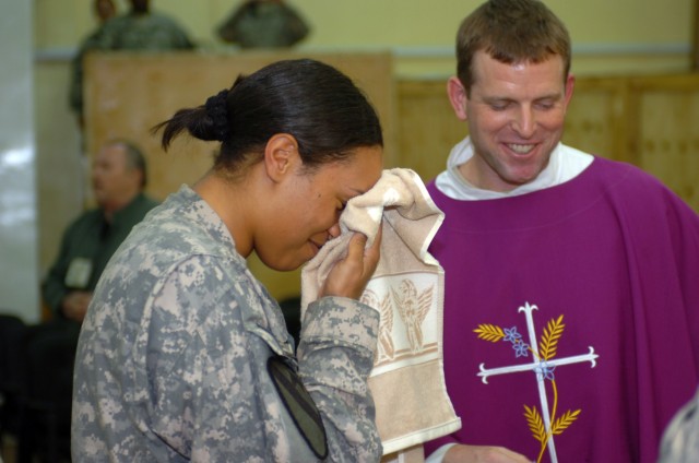 CAMP TAJI, Iraq- 1st Lt. Marjana Mair (left), from Albany, N.Y., smiles as she wipes water from her face after being baptised by Chaplain (Maj.) Tyson Wood (right), from Long Beach Island, N.J., as part of a confirmation ceremony at the Tigris...
