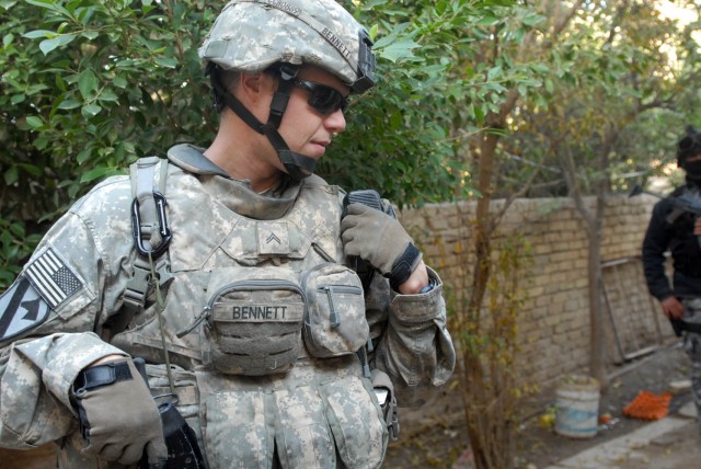 BAGHDAD - St. Mary's County, Md. native, Cpl. Timothy Bennett, a team leader assigned to the 1st Squadron, 7th Cavalry Regiment, 1st Brigade Combat Team, 1st Cavalry Division, communicates with his platoon leader, Dec. 11, outside Joint Security...
