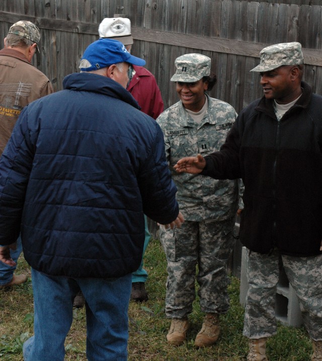 Cpt. Deveilla Lambert, commander and Master Sgt. Donald Hutchinson, senior non-commissioned officer, both of the 15th Special Troops Battalion rear detachment meet with the Knight of Columbus members on the first day of the project at the home of...