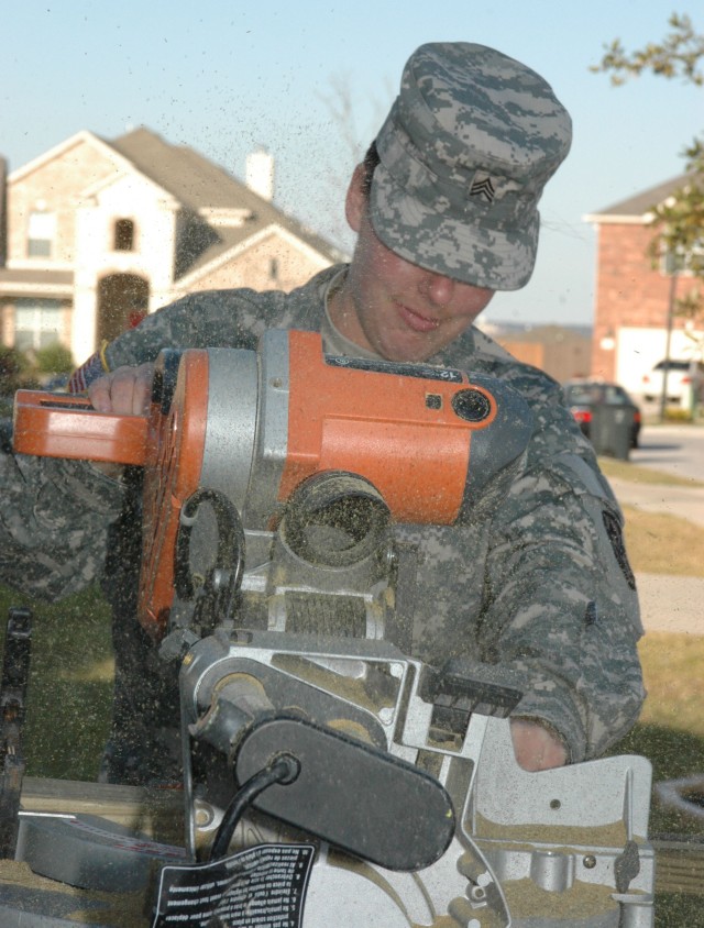 Sgt. Destony Troy, legal liaison and command finance specialist for the 15th Sustainment Brigade, a native of Odessa, Texas, cut wood for the wheelchair ramp and deck project at the home of Sgt. Kimberly Munley, the civilian officer who was...