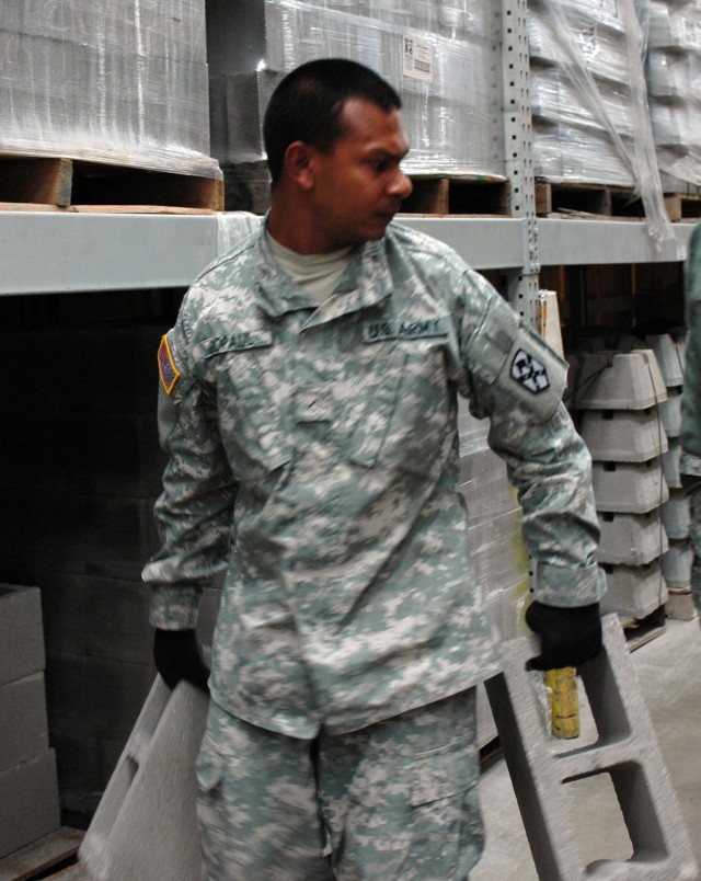 Pvt. Nathaniel Gopaul, a transportation management coordinator and a South Jamaica, N.Y., native, with the 15th Sustainment Brigade, loads cinder blocks on to a forklift for the wheelchair ramp and deck project at the home of Sgt. Kimberly Munley,...