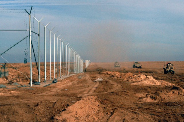 CONTINGENCY OPERATING LOCATION Q-WEST, Iraq - Gun trucks of the force protection company skirt the perimeter fence of Contingency Operating Location Q-West during a presence patrol, Dec. 15. The Soldiers serve with the Mississippi Army National...