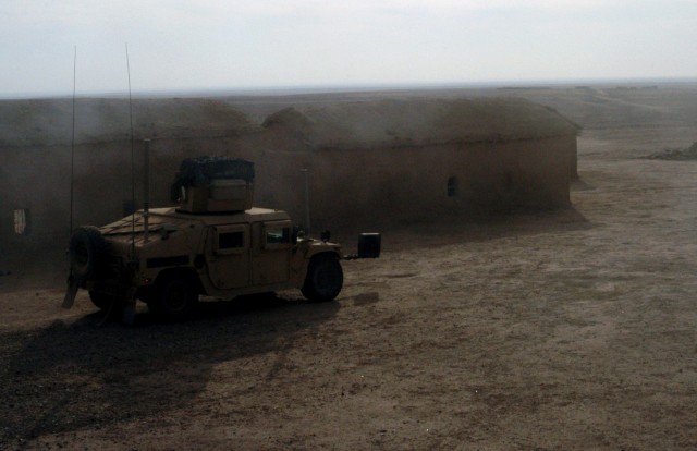 CONTINGENCY OPERATING LOCATION Q-WEST, Iraq - A Mine-Resistant, Ambush-Protected gun truck of the force protection company conducts a presence patrol through an abandoned village near Contingency Operating Location Q-West, Dec. 15. The Soldiers...