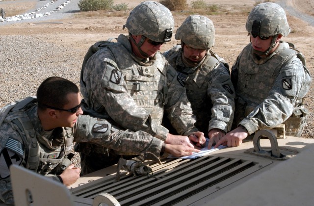 CONTINGENCY OPERATING LOCATION Q-WEST, Iraq - Squad and team leaders of the quick reaction force confer before a presence patrol at the Base Defense Operations Center, Contingency Operating Location Q-West, Dec. 15. The Soldiers serve with A...