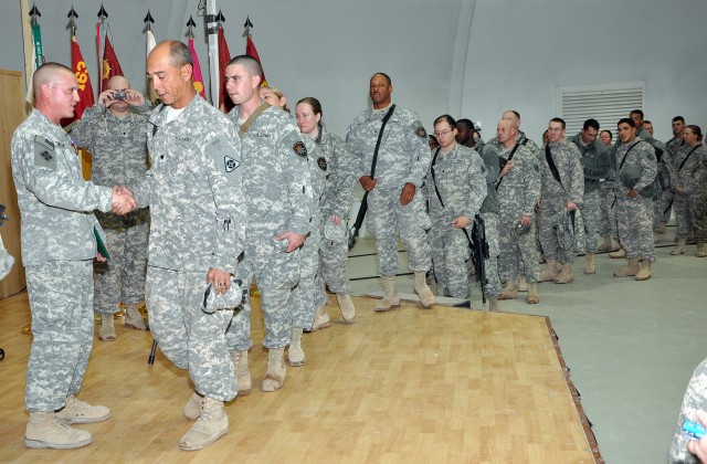 Soldiers congratulate Staff Sgt. Justin Taylor, a Lancaster, Pa., native and assistant platoon sergeant for the 733rd Trans. Co., 395th CSSB stationed in Reading, Pa., after a ceremony awarding him the Purple Heart here Dec. 17 for an injury...