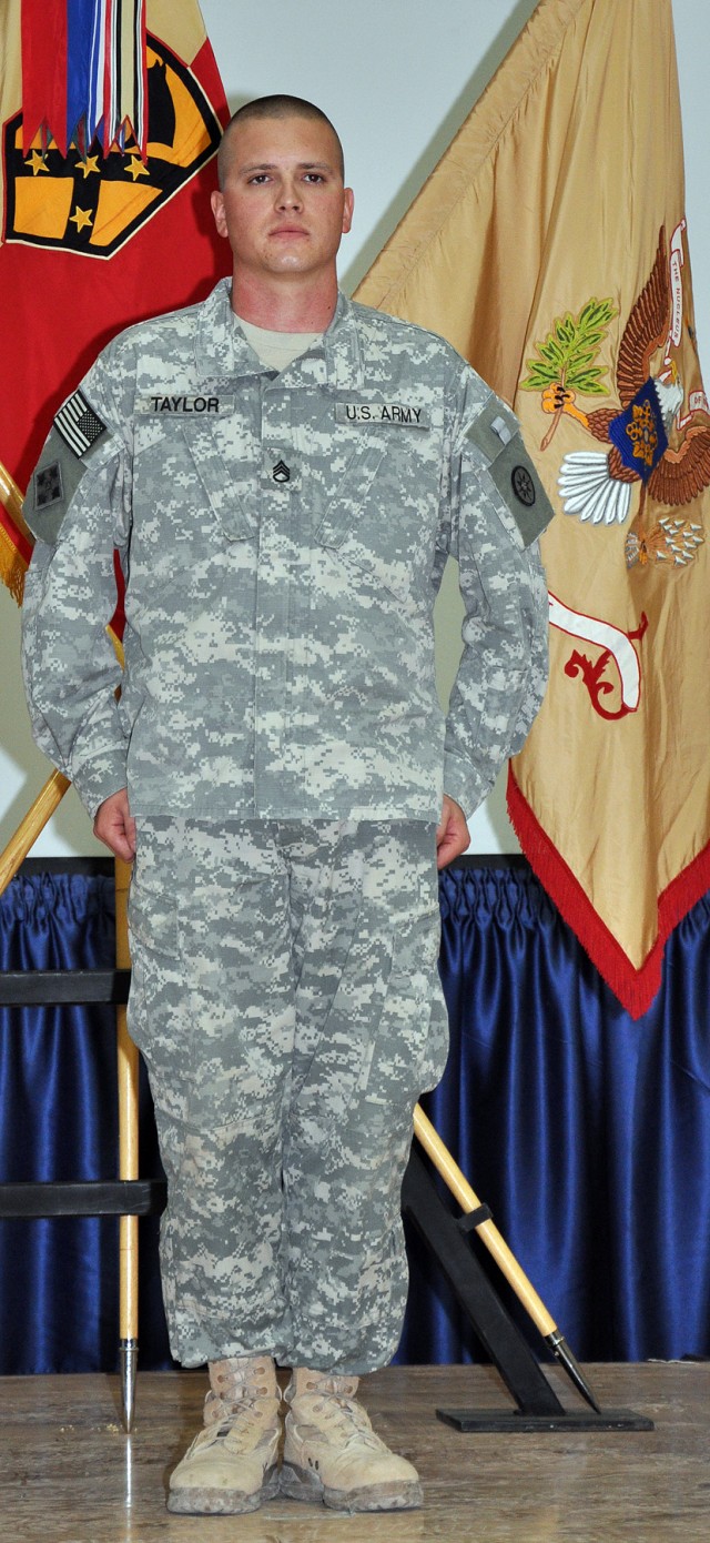 Staff Sgt. Justin Taylor, a Lancaster, Pa., native and assistant platoon sergeant for the 733rd Trans. Co., 395th CSSB stationed in Reading, Pa., stands at attention before receiving the Purple Heart here Dec. 17 for an injury sustained in a...
